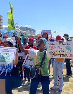 Protestors hold up Extinction Rebellion flag and posters saying