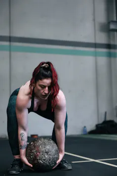 Strongwoman Zoya Huschtscha attempts to lift a stone during a strongwoman event