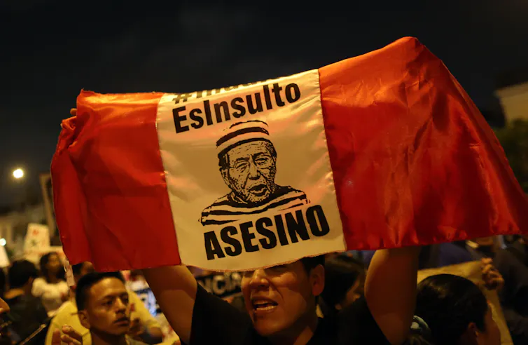 Protestors holding a Peru flag with a picture of Fujimori reading
