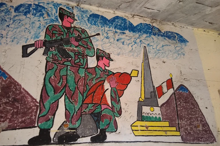 A painting of two soldiers in camouflage clothing on a wall.
