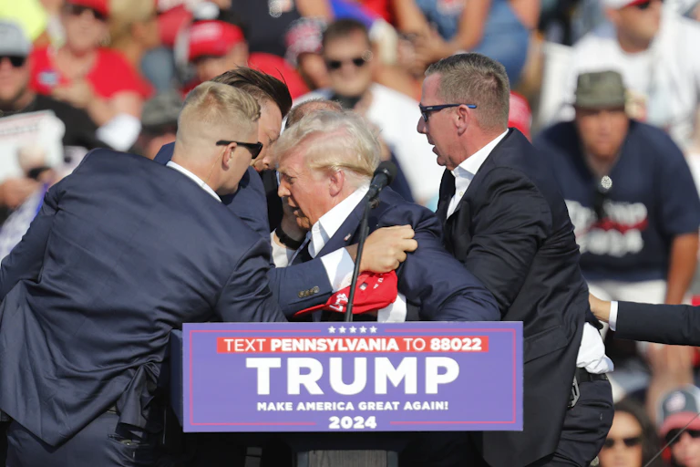 Donald Trump being surrounded by his security detail after being shot at a rally in Pennsylvania