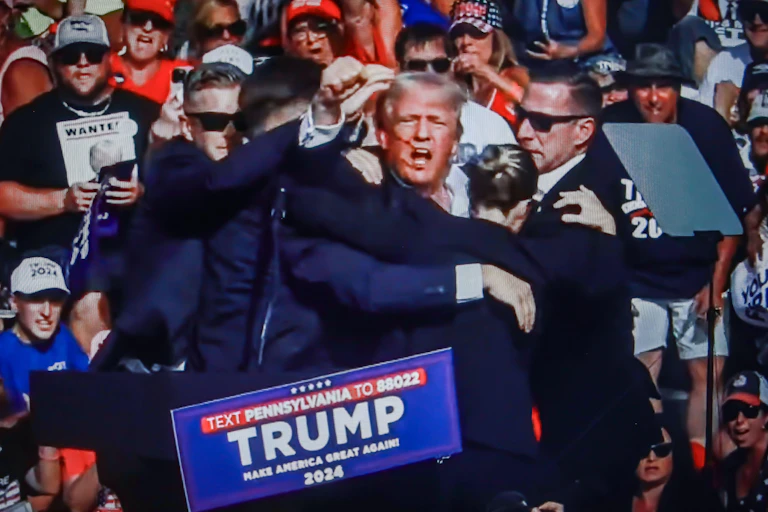 Image of Donald Trump with blood on his face surrounded yb secret service officers