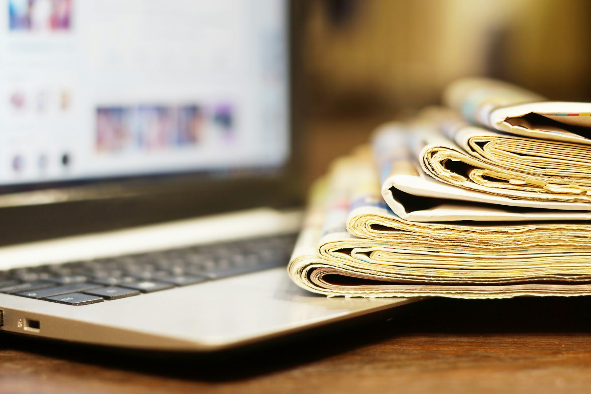Une pile de journaux repose sur un ordinateur portable
