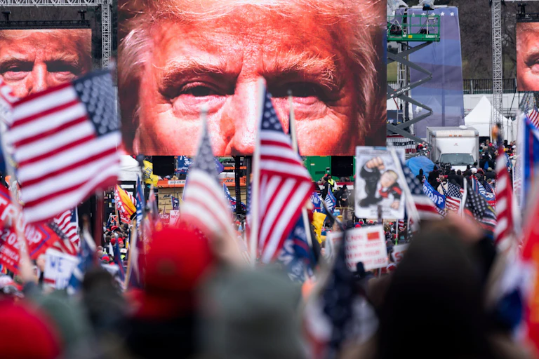 Trump supporters watch him on a big screen on January 6 2021.