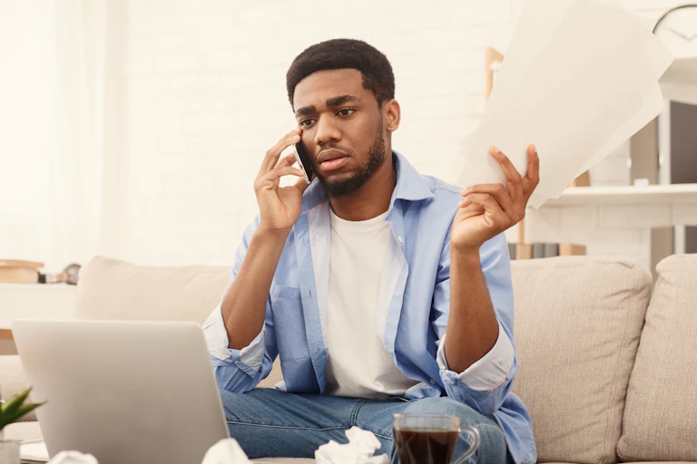 man with paperwork talking on the phone