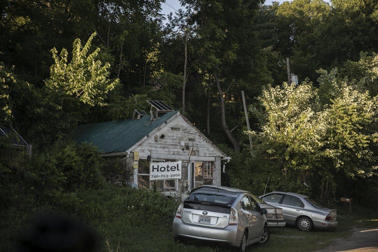 A rundown building with a 'hotel' sign on its front.