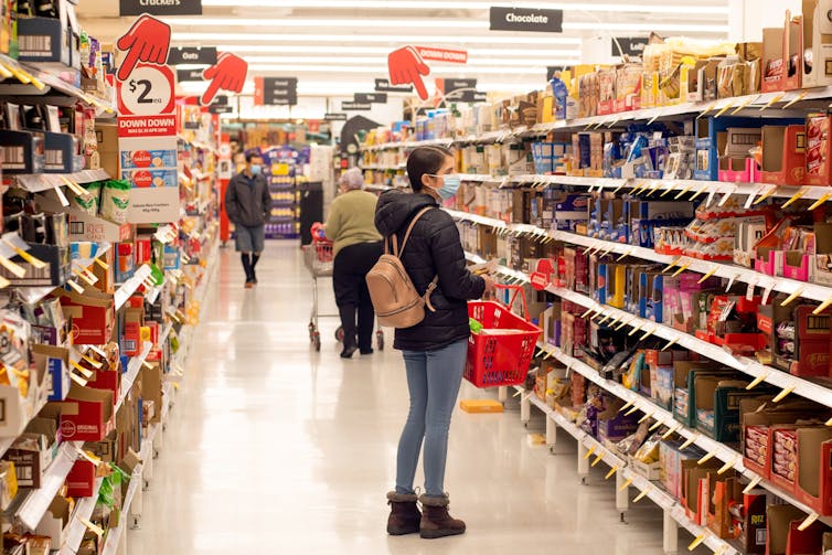 woman looking at supermarket shelves