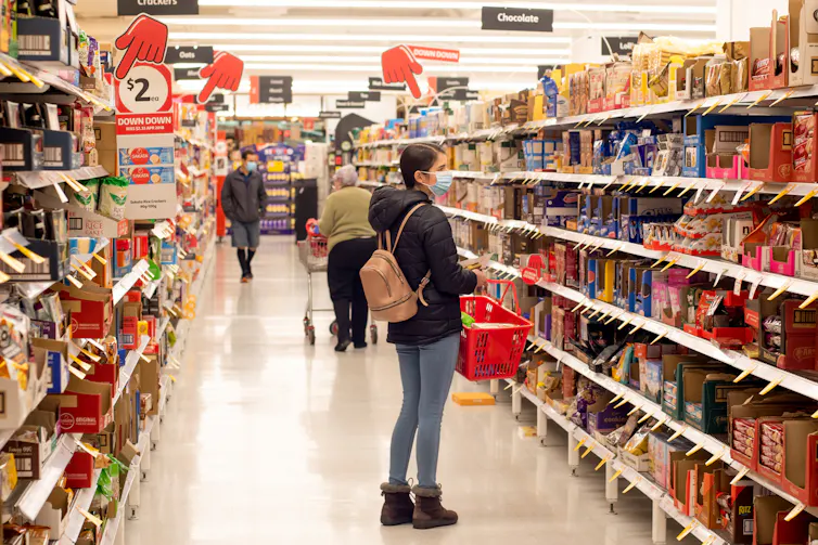 woman looking at supermarket shelves
