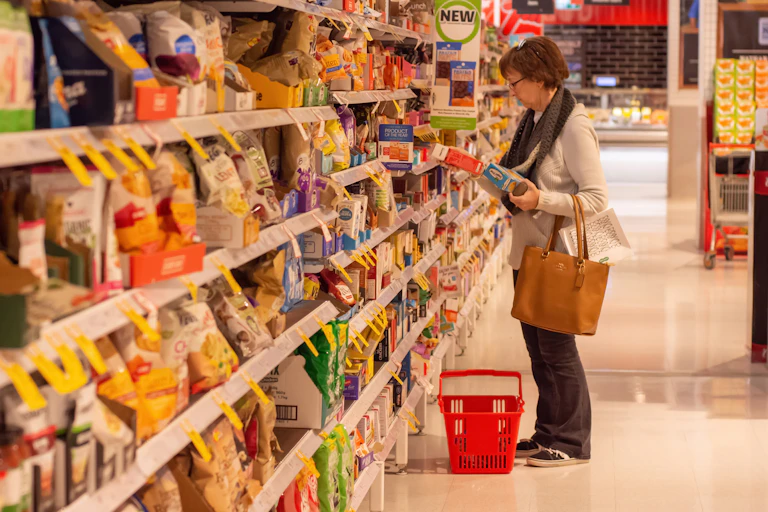 woman looking at item in supermarket