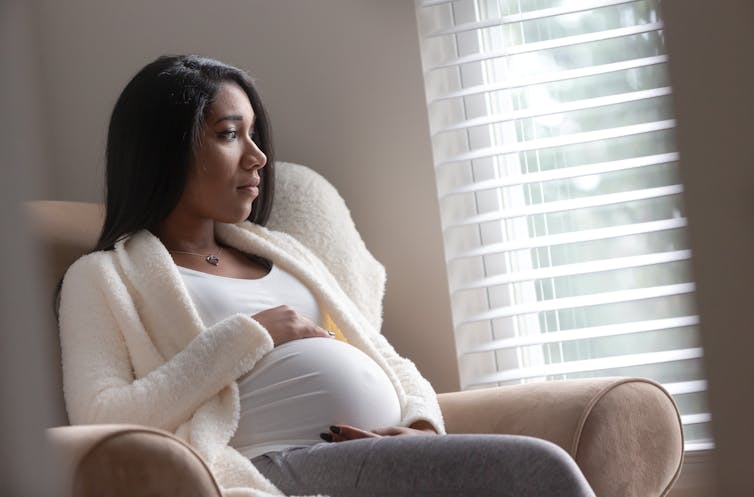 Pregnant First Nations woman looks out the window