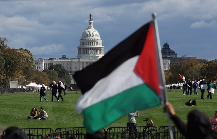A black, white, green and red flag is seen in front of the U.S. Capitol building