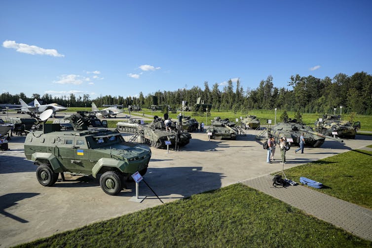 Танки и другая военная техника под голубым небом.