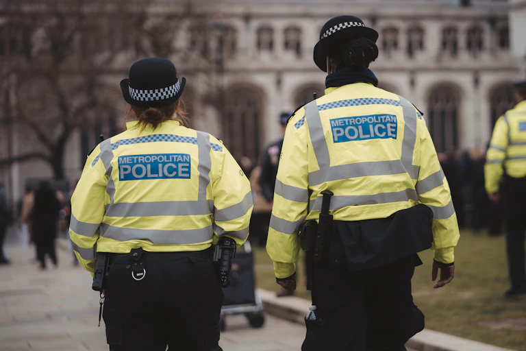 View from behind of two female Met police officers walking in Westminster