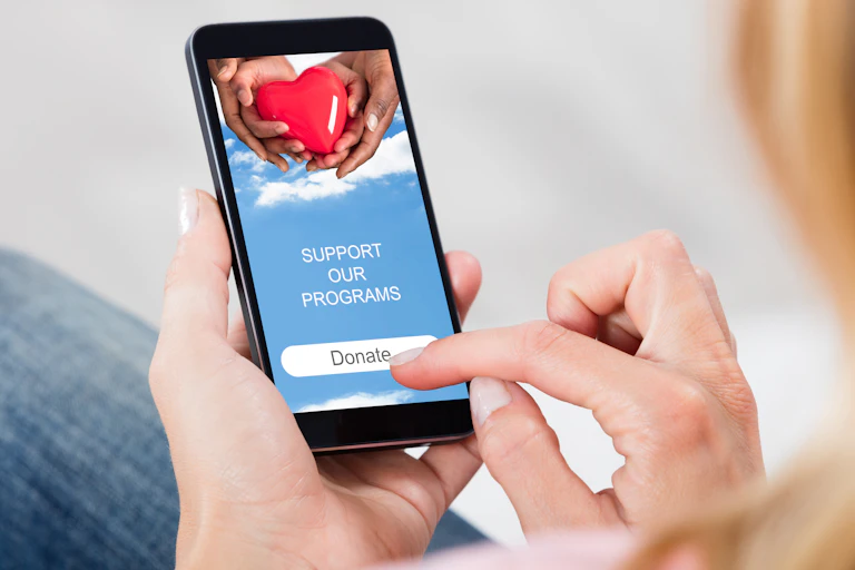 Close-up Of Woman Hand Reading News On Mobile Phone At Home