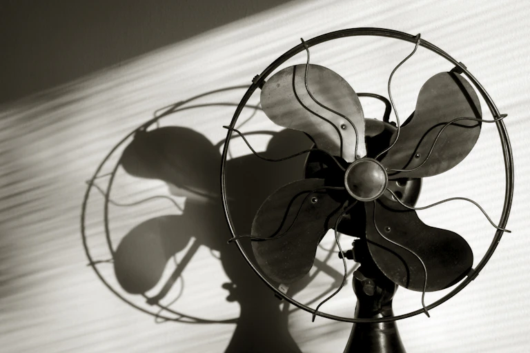 An old electric fan sits on a table