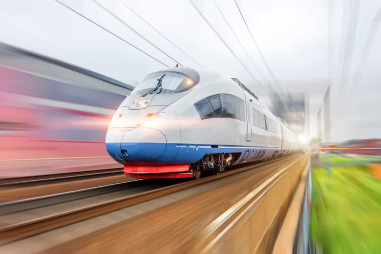 Electric passenger train with glowing lights traveling at high speed
