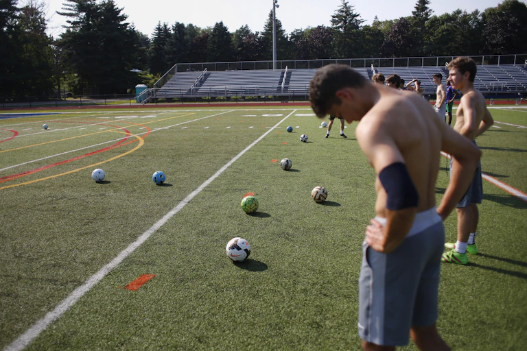 Soccer players catch their breath on the field with several soccer balls in front of them. The temperature was over 90F that day, Aug. 6, 2018, in Portland, Maine.
