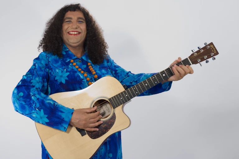 A woman in a blue shirt holding a guitar.