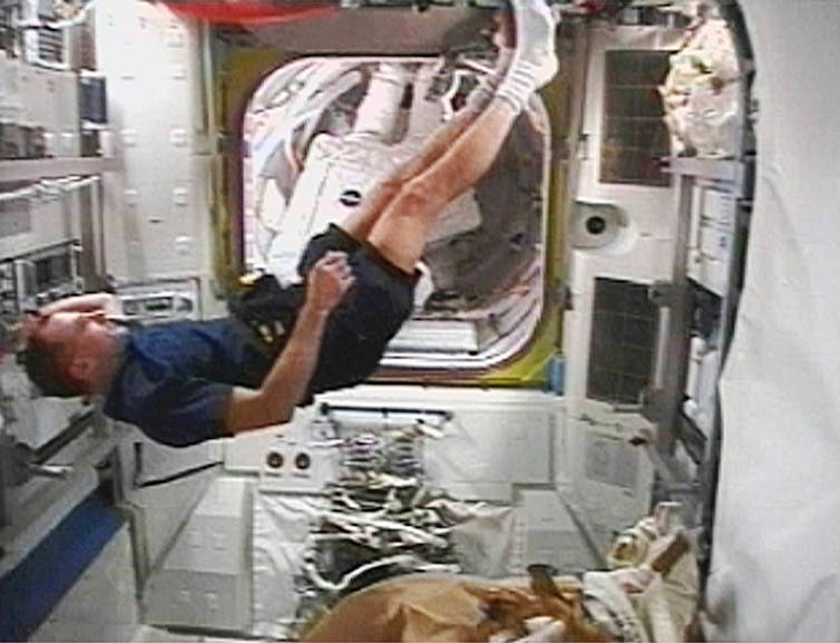 A man floating in a spaceship.