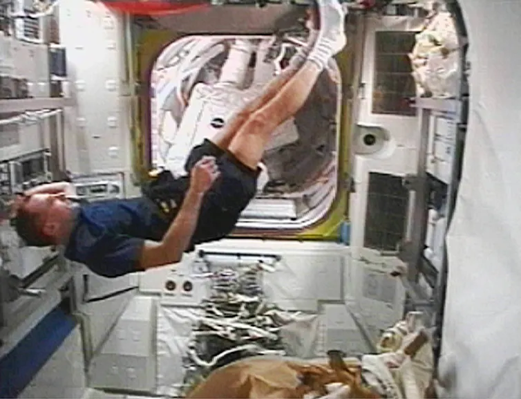 A man floating in a spaceship.