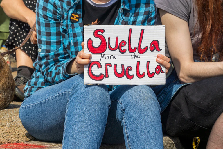 Protestor holding up Suella more like Cruella placard