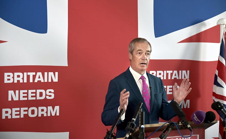 Nigel Farage falando em frente a uma bandeira do Reino Unido
