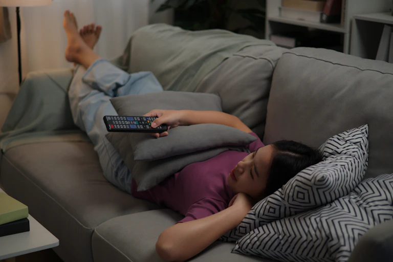 woman lying on sofa and enjoy watching movie television