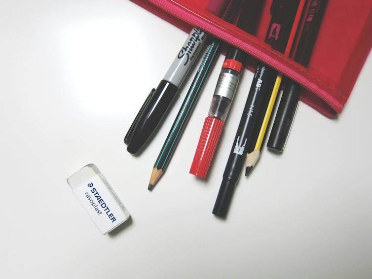 A pencil case, with pens and pencils poking out.