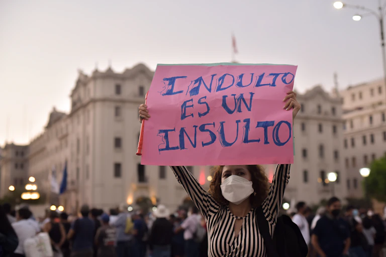Mujer sostiene una pancarta en la que se lee: "Indulto es un insulto"