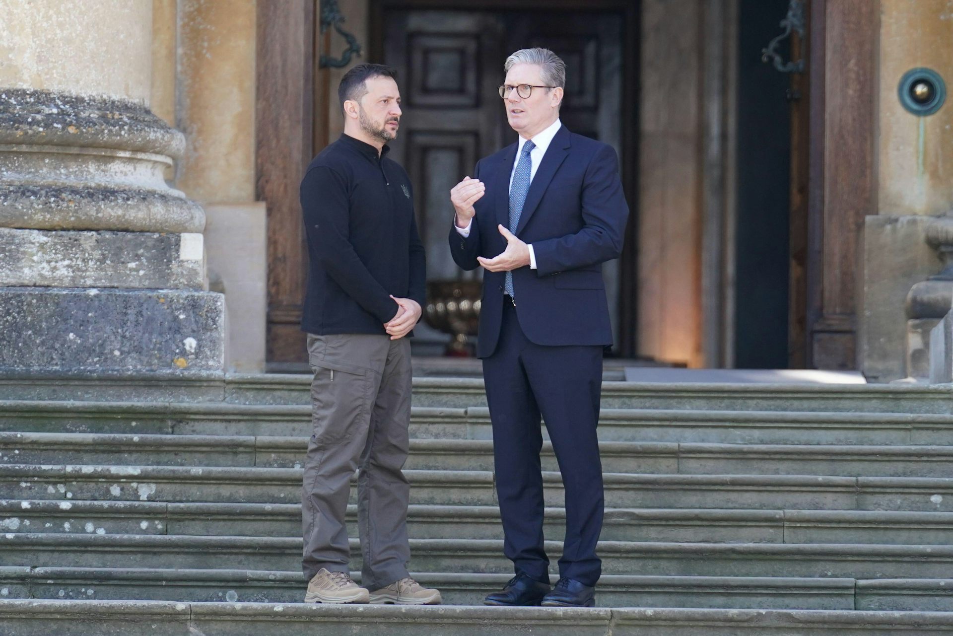 UK prime minister Keir Starmer stands with Ukrainian president Volodymyr Zelensky on the steps of a large building.