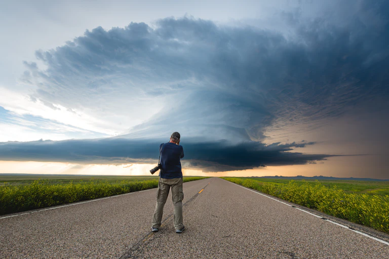 man photographs large storm cloud