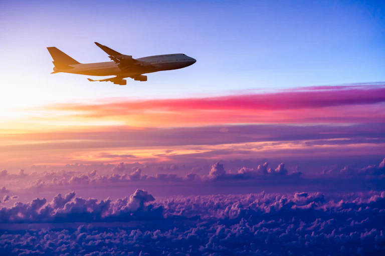 Plane in the sky with sunset background.