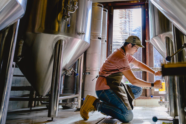 Un homme agenouillé rempli une pinte de bière
