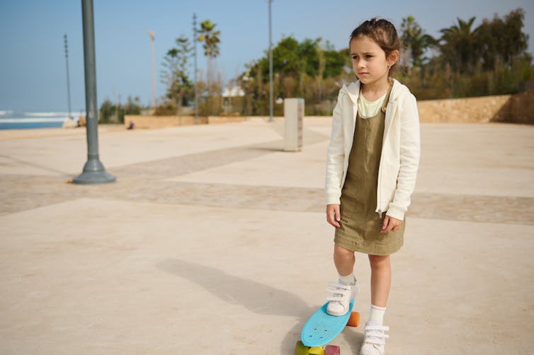 sad looking girl on the margins of a skate park.