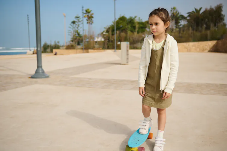 sad looking girl on the margins of a skate park.