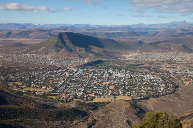 An aerial view of a town set against a mountain, divided into three residential zones.