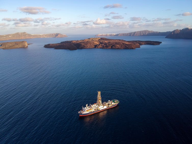 aerial view of ship on blue sea with islands in background