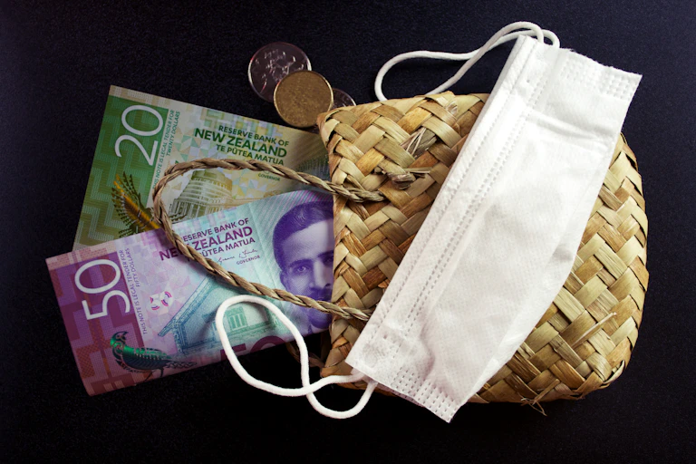 montage of money, face mask and flax kete