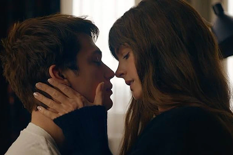 A man and woman embrace and lean in for a kiss