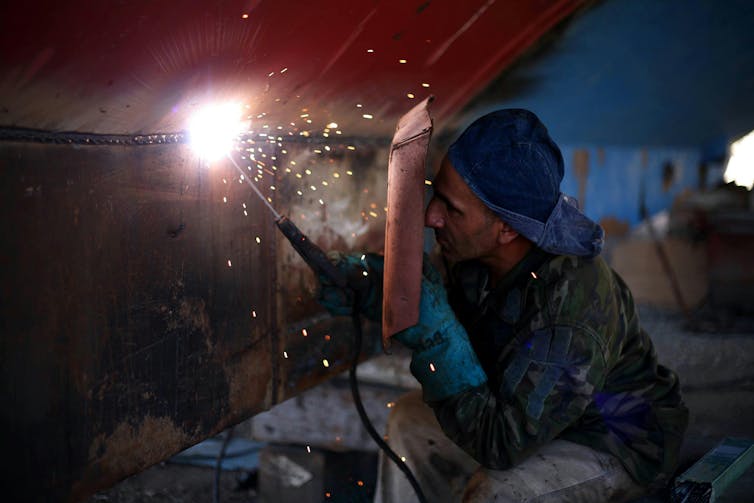 A man does welding.