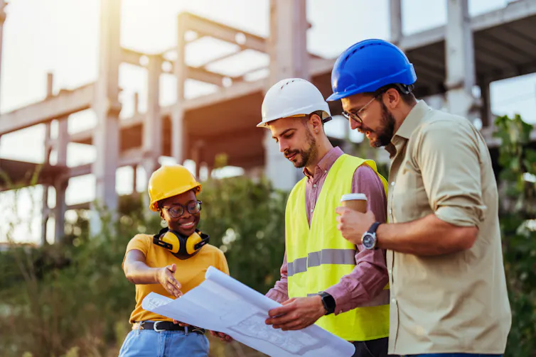 Three construction workers outdoors.