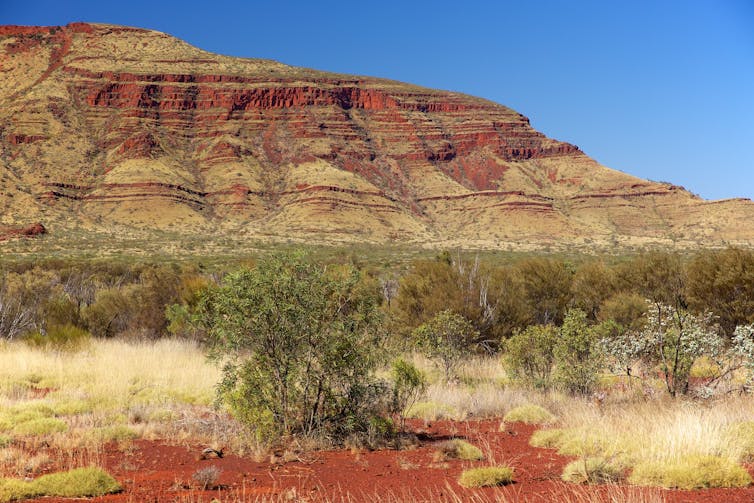 A medium distance view of a weathered mountain with bands of rock clearly visible.