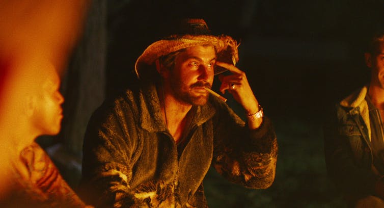 A man next to a camp fire.