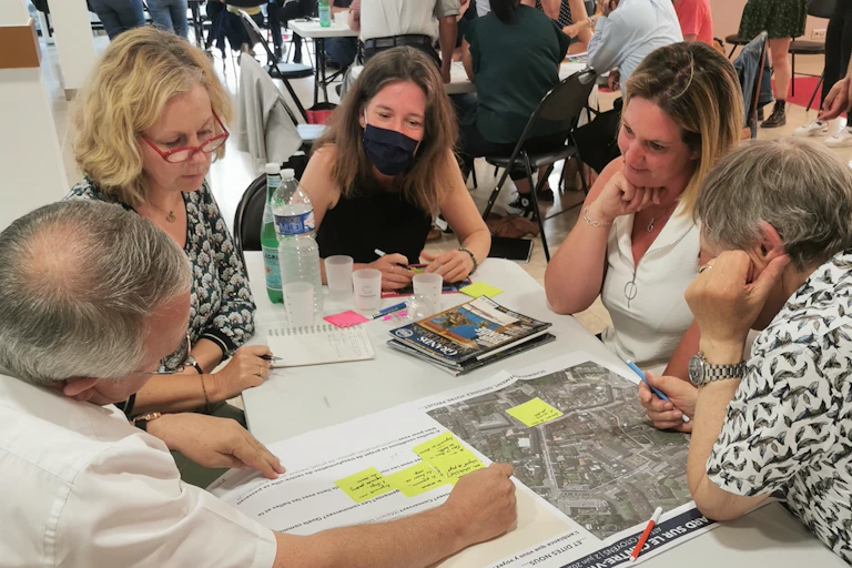 personnes assises autour d'une table qui regardent un document