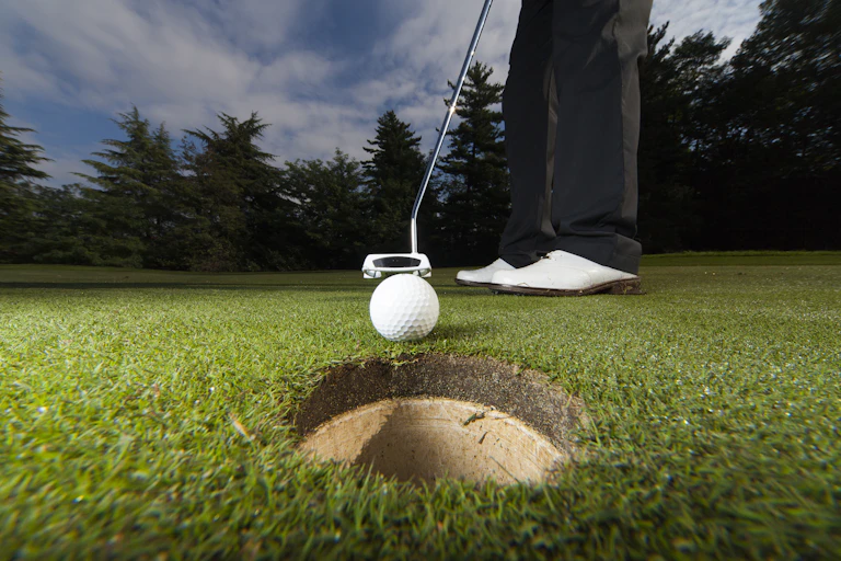 Golfing putting a ball close to the hole