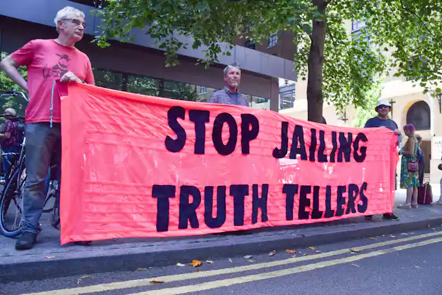 protesters with 'stop jailing truth tellers' banner