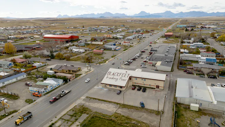 Aerial view of a small town with mountains looming in the background