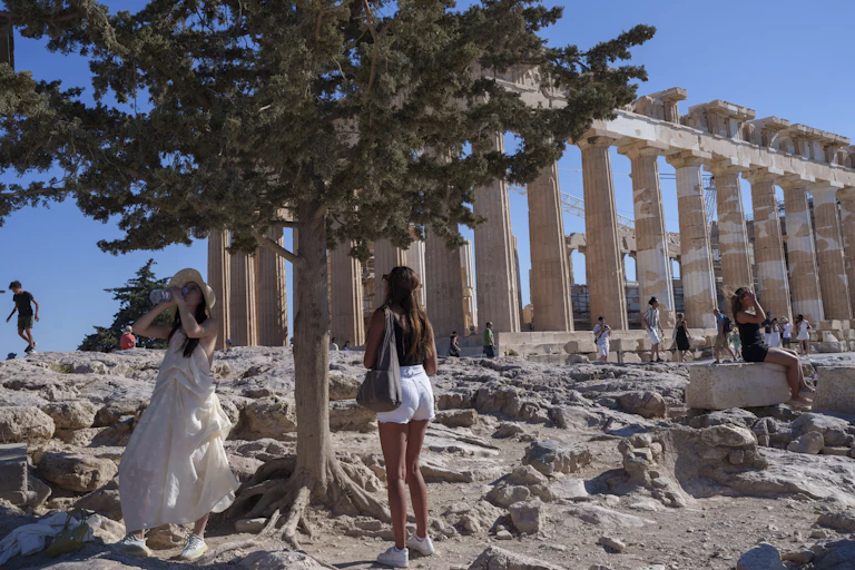 Two women stand by a ruined building.