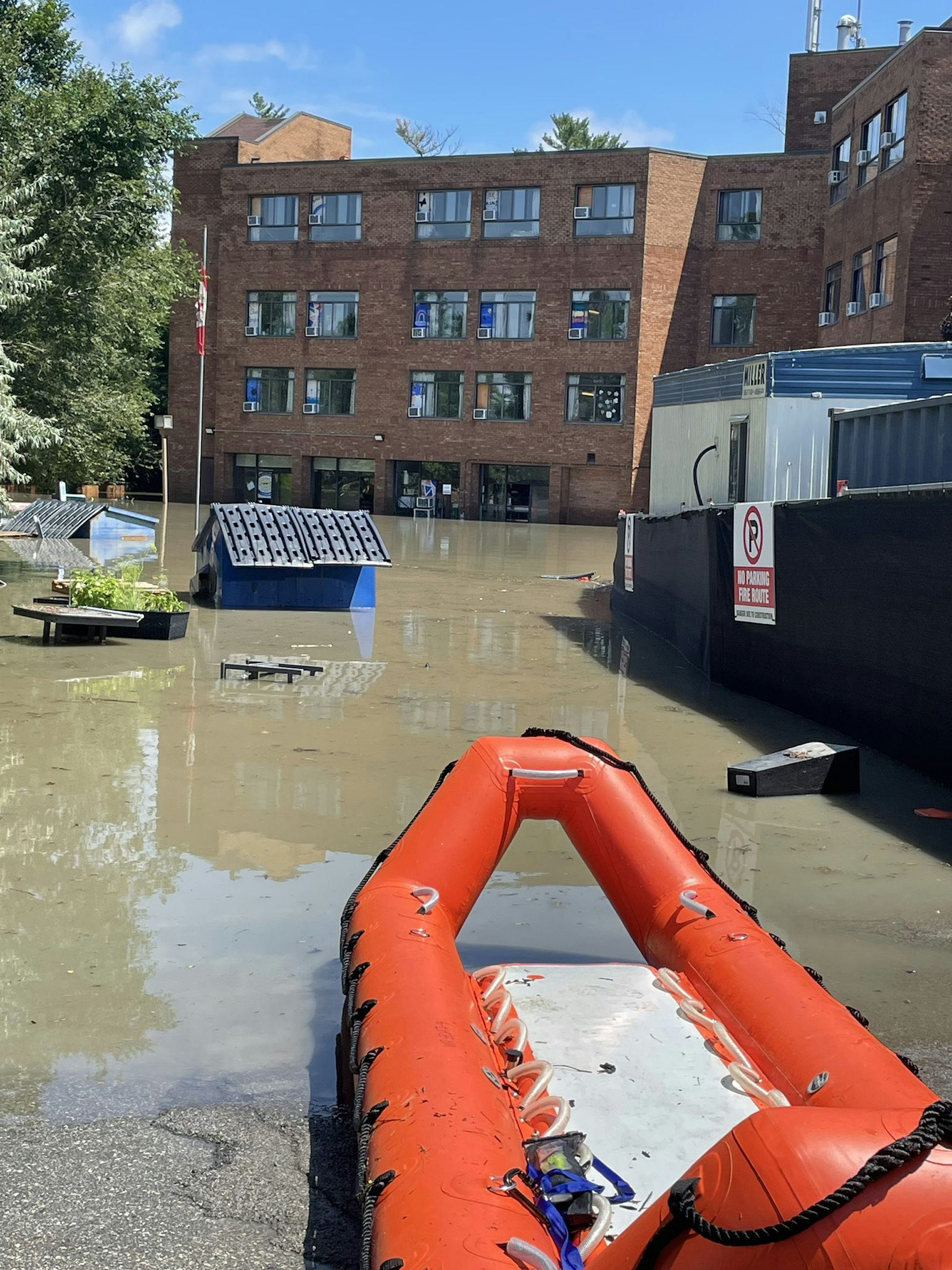 A flooded building is seen with a boad in the foreground.