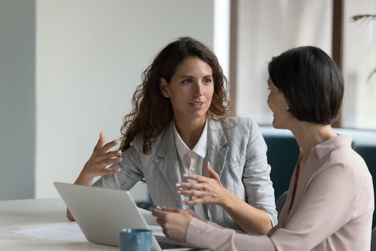 Two women having a discussion in an office setting